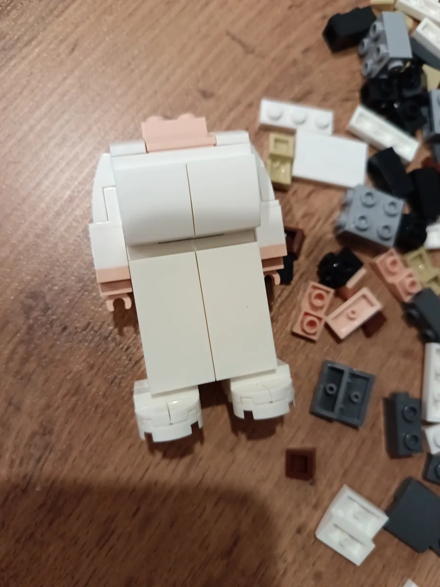Фигурка-конструктор BrickMe со спины в процессе сборки, вокруг разложены детали